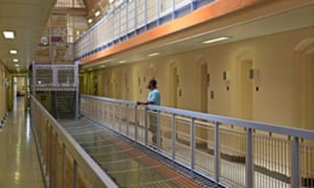 A prisoner stands outside his cell on C wing of HMP Wandsworth in south-west London