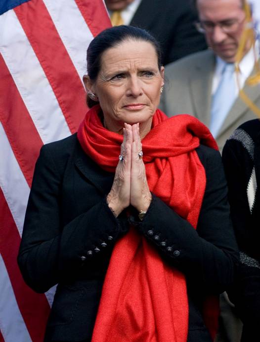 Jean Schmidt holds her hands together in a prayer-like gesture, face grave.