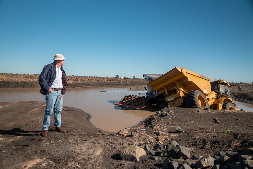 Farmer Bud Kelly looks at bogged machinery on an old rail corridor, Pampas, Queensland, August 2022.